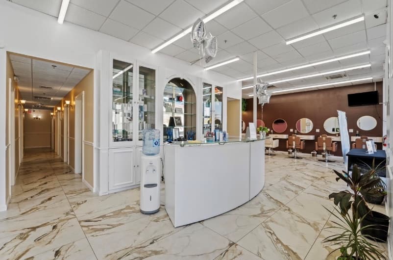 ReVibe reception desk on a marble floor, with glass display cabinets and the styling floor beyond