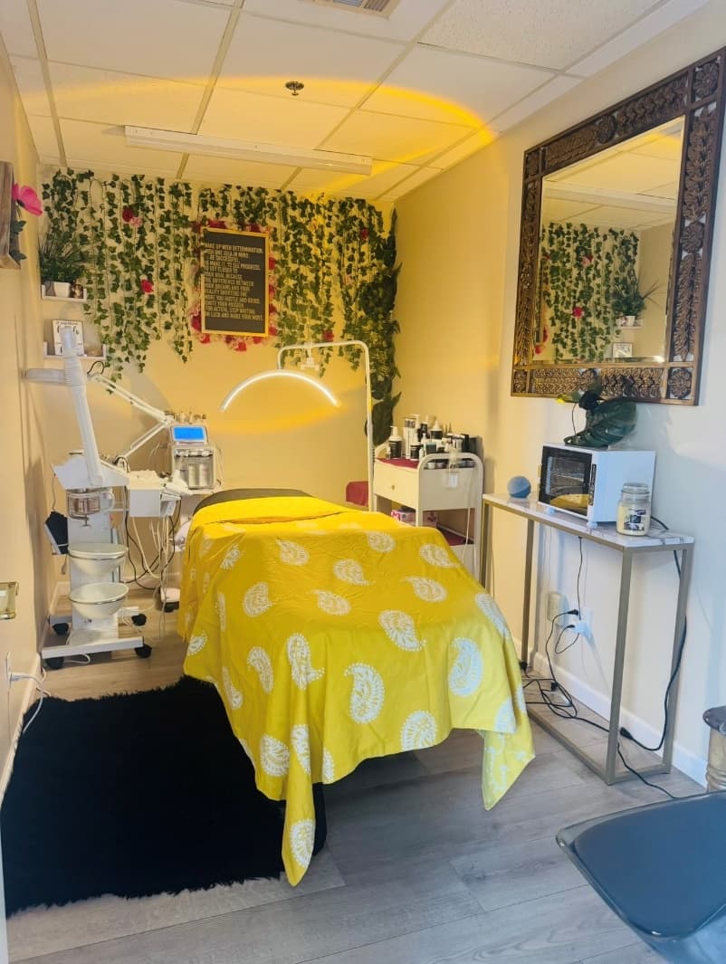 ReVibe Skin Renewal Studio with a facial bed, skin-care equipment, a wall of vines and an ornate mirror
